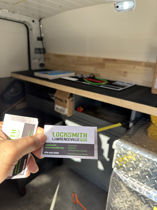 Inside the Locksmith Lawrenceville Pro van, showing a workbench, storage drawers and a branded business card